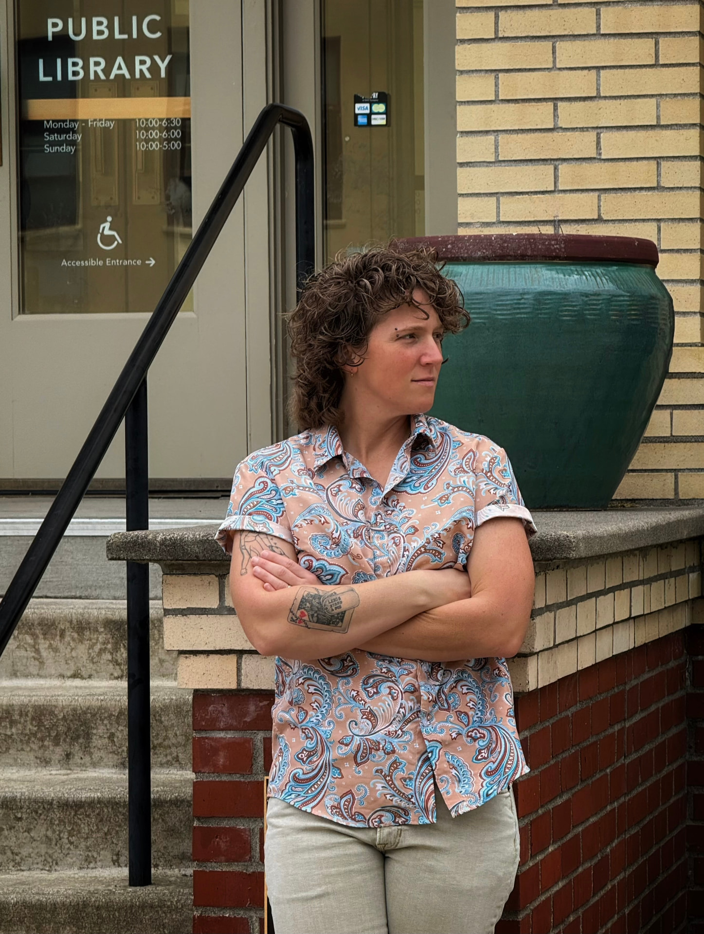 King Faber, independent author and creator, standing outside a public library with arms crossed